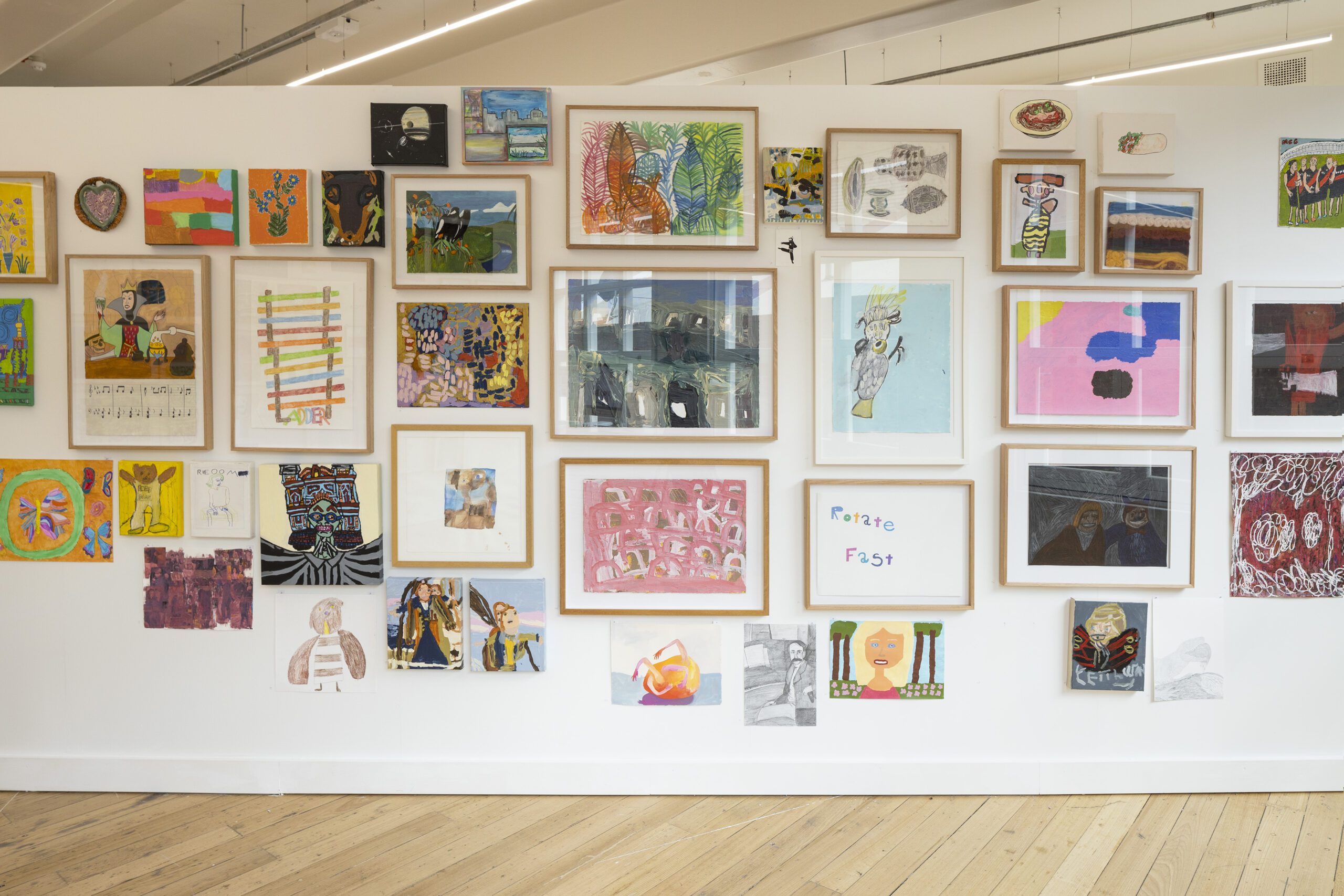 A photo of artworks hung in a salon style at the APA gallery