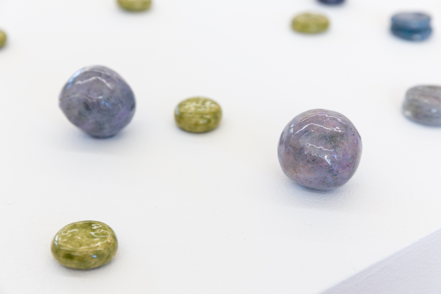 Small circle ceramic sculptures displayed on a flat surface