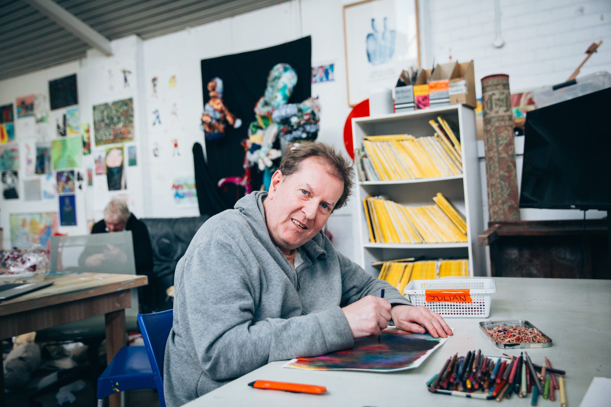 Artist Julian Martin drawing in the Arts Project Australia Studio